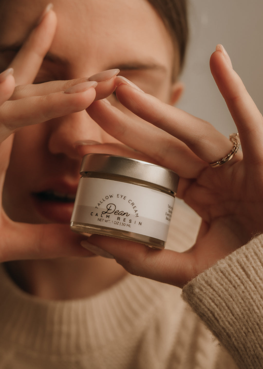 Person holding a jar of cream with a blurred background