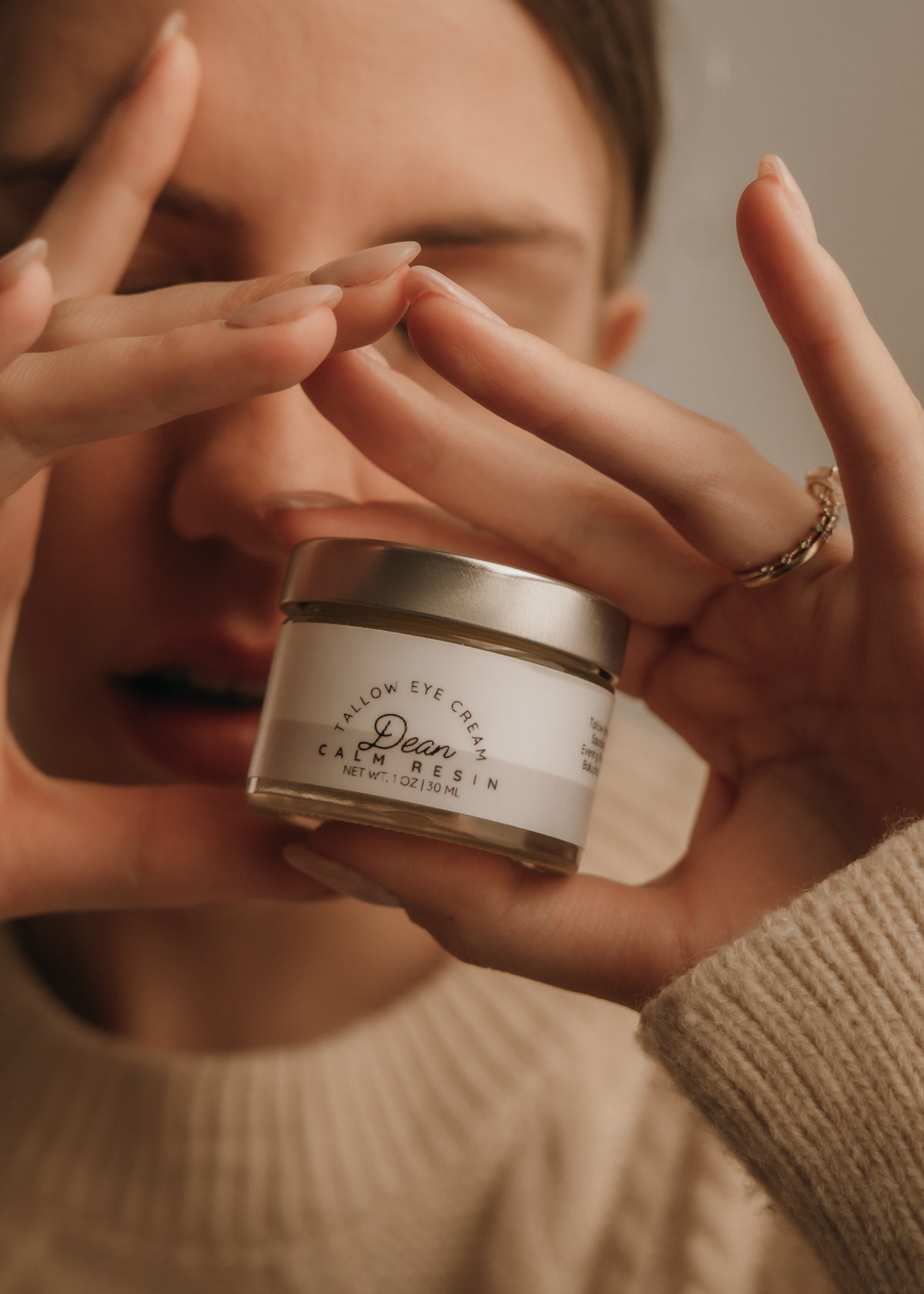 Person holding a jar of cream with a blurred background