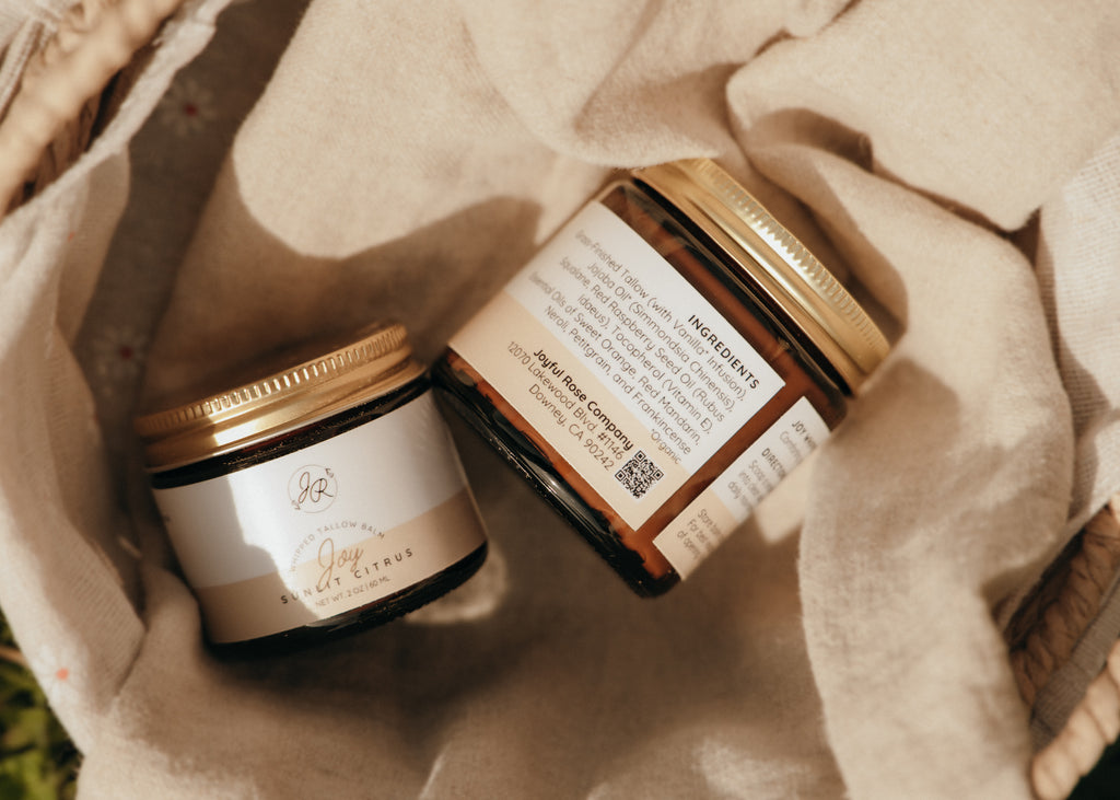 Two jars with gold lids on a beige fabric background