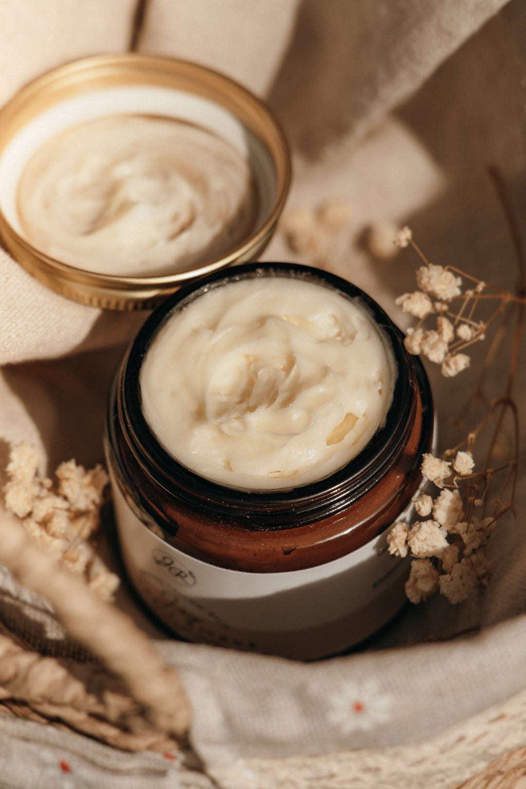 Jar of cream with a lid on a textured surface
