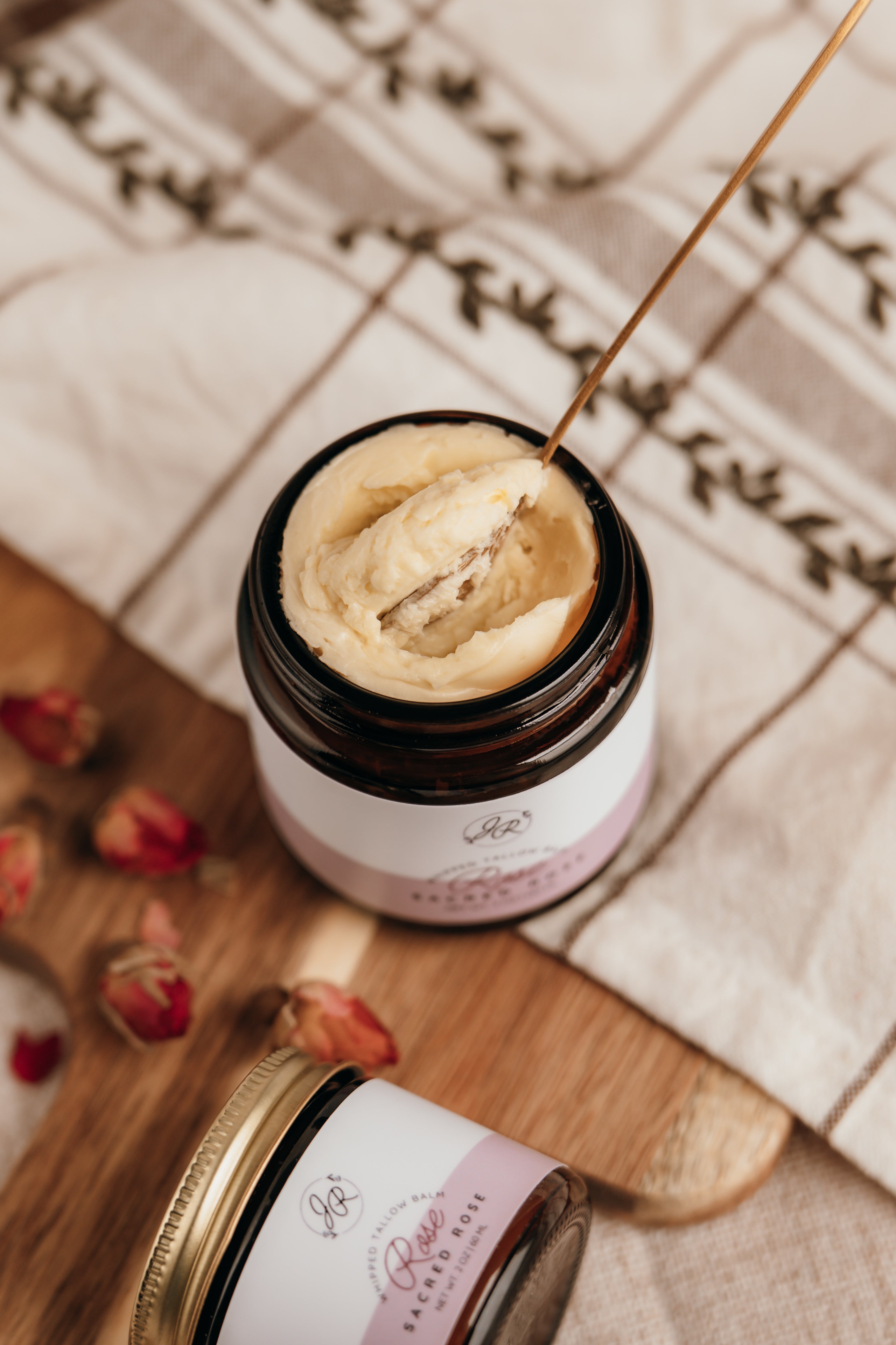 Jar of cream with a spoon on a wooden surface and checkered cloth background