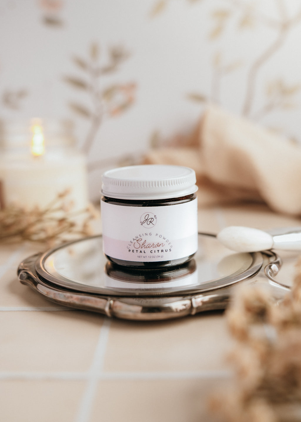 Jar of cream on a silver tray with a blurred background