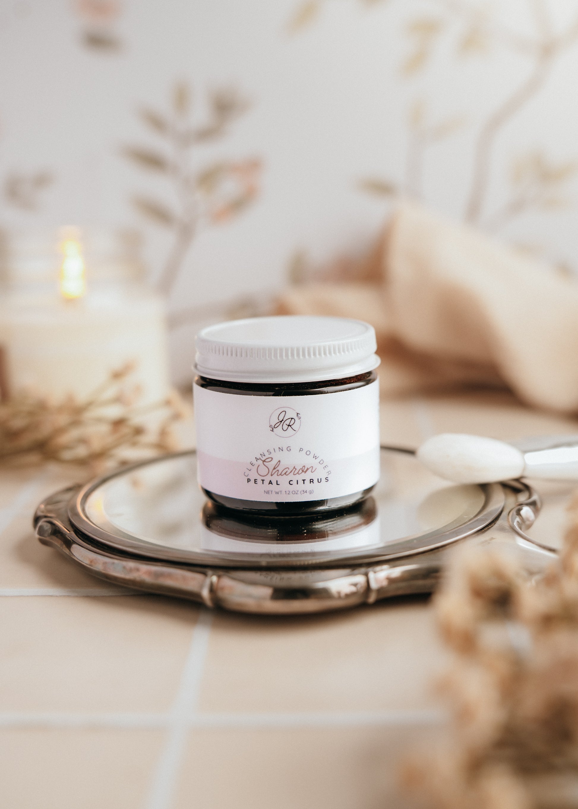 Jar of cream on a silver tray with a blurred background