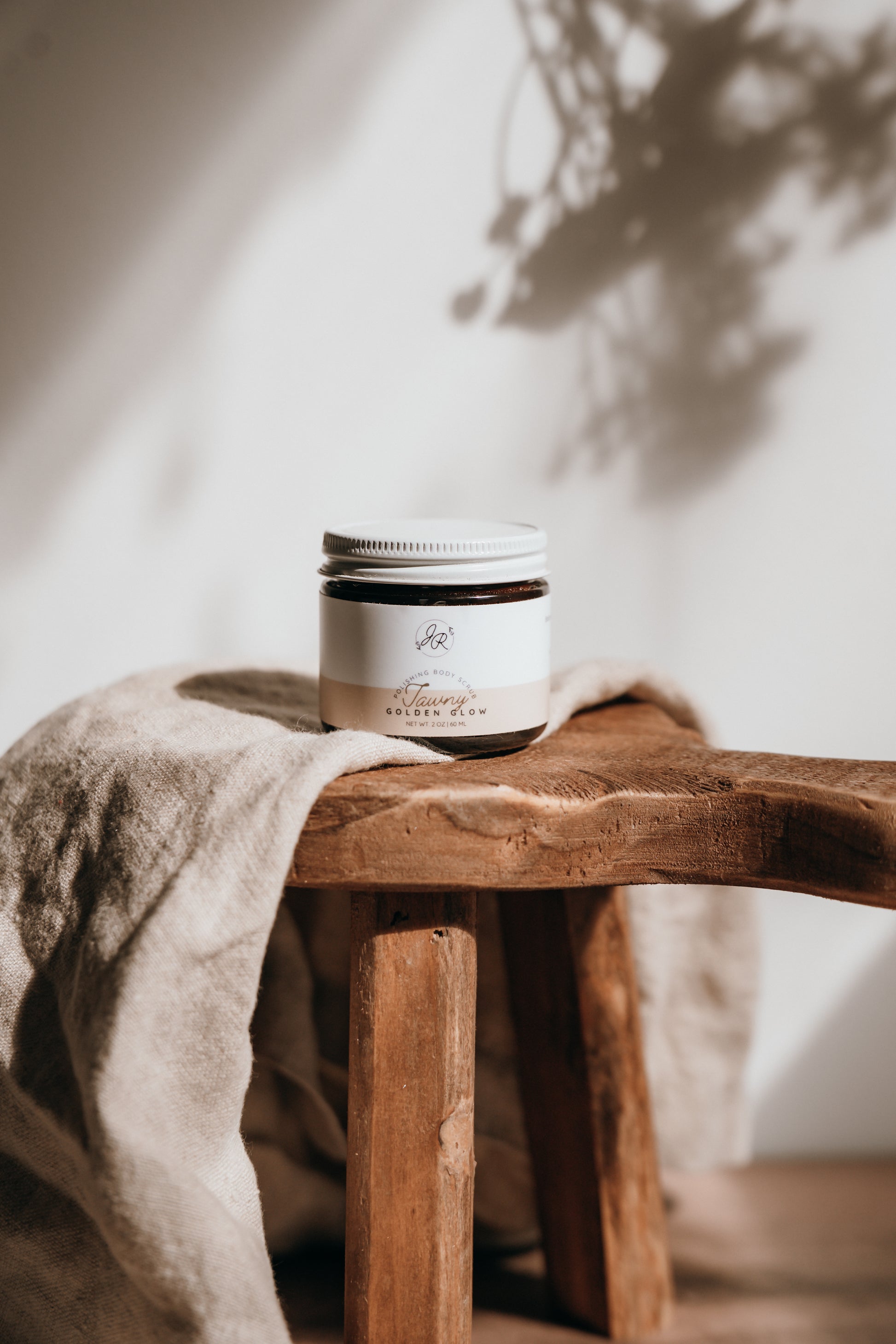Jar of cream on a wooden stool with a neutral background